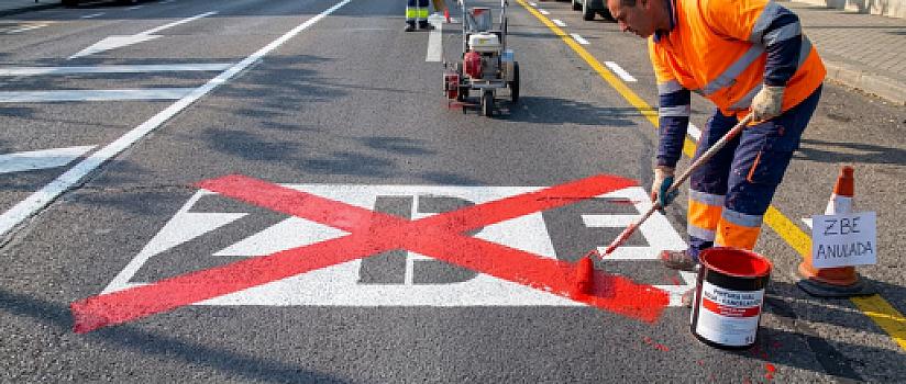 operario pintando con una X roja la senal de zona de bajas emisiones